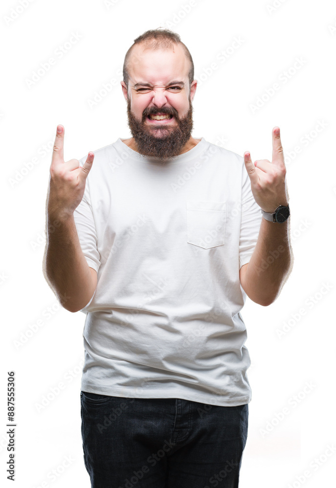 Naklejka premium Young caucasian hipster man wearing casual t-shirt over isolated background shouting with crazy expression doing rock symbol with hands up. Music star. Heavy concept.