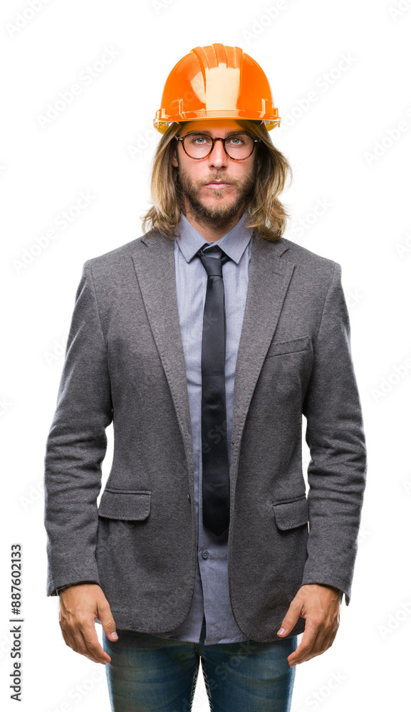 Young handsome architec man with long hair wearing safety helmet over isolated background with serious expression on face. Simple and natural looking at the camera. Young handsome architec man with long hair wearing safety helmet over isolated background with serious expression on face. Simple and natural looking at the camera.