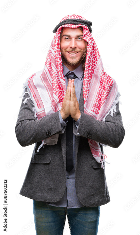 Young handsome arabian man with long hair wearing keffiyeh over isolated background praying with hands together asking for forgiveness smiling confident. Young handsome arabian man with long hair wearing keffiyeh over isolated background praying with hands together asking for forgiveness smiling confident.