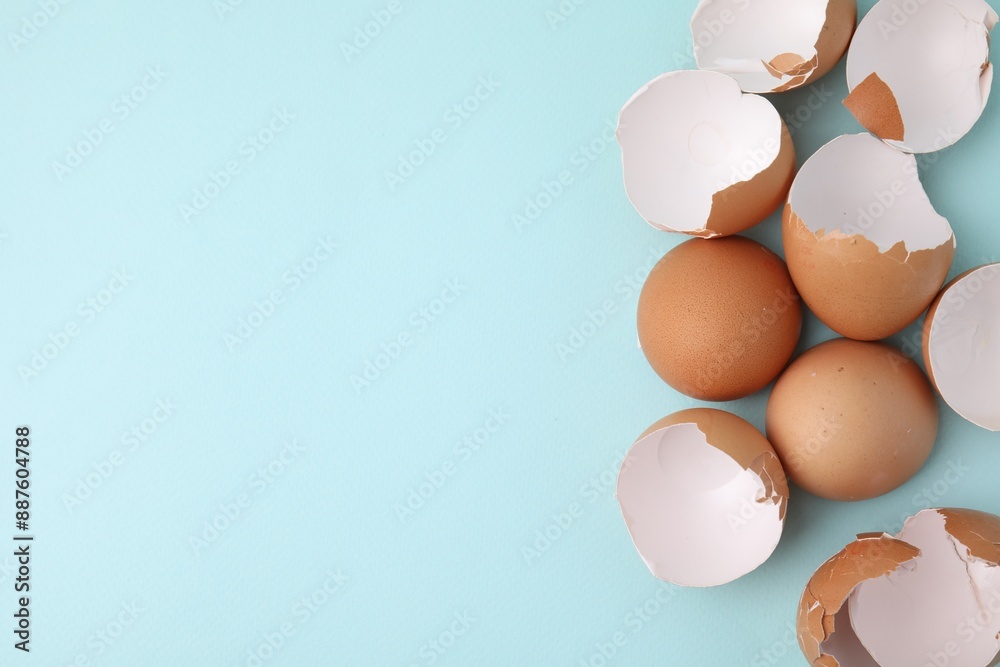 Broken eggshells on light blue background, top view. Space for text Broken eggshells on light blue background, top view. Space for text