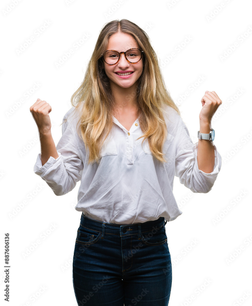 Young beautiful blonde business woman wearing glasses over isolated background celebrating surprised and amazed for success with arms raised and open eyes. Winner concept. Young beautiful blonde business woman wearing glasses over isolated background celebrating surprised and amazed for success with arms raised and open eyes. Winner concept.
