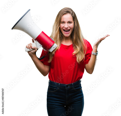 Young beautiful blonde woman yelling through megaphone over isolated background very happy and excited, winner expression celebrating victory screaming with big smile and raised hands