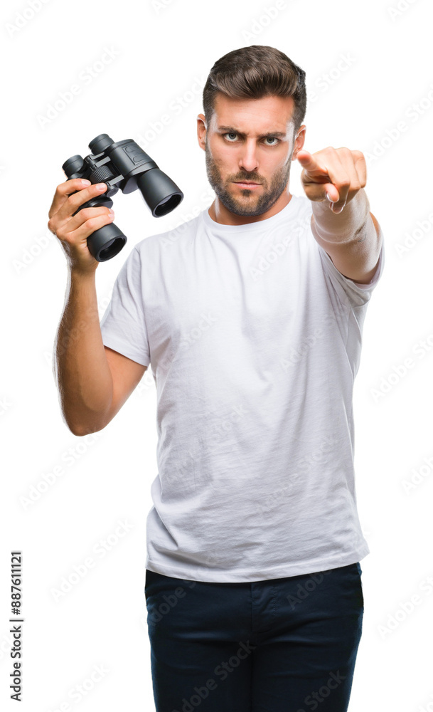 Young handsome man looking through binoculars over isolated background pointing with finger to the camera and to you, hand sign, positive and confident gesture from the front Young handsome man looking through binoculars over isolated background pointing with finger to the camera and to you, hand sign, positive and confident gesture from the front