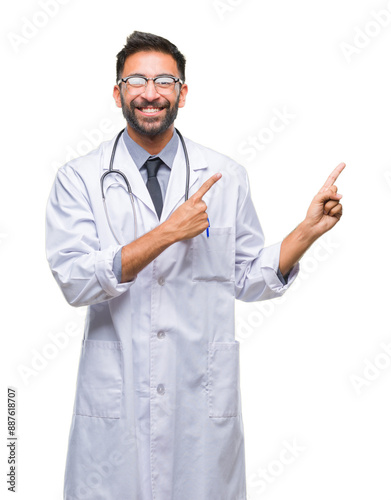 Adult hispanic doctor man over isolated background smiling and looking at the camera pointing with two hands and fingers to the side.