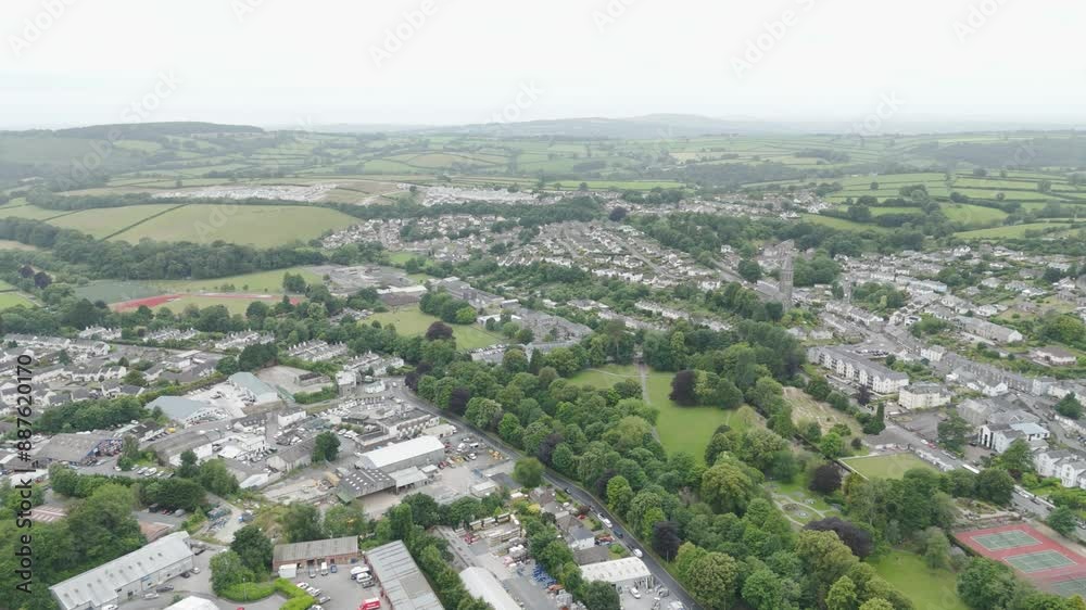 Aerial flyover of the west side of Tavistock, showcasing residential areas, green fields, and winding roads, Devon, UK Aerial flyover of the west side of Tavistock, showcasing residential areas, green fields, and winding roads, Devon, UK