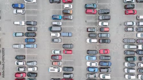 Top-down flyover of a busy UK carpark with numerous parked cars, highlighting the organized parking layout
