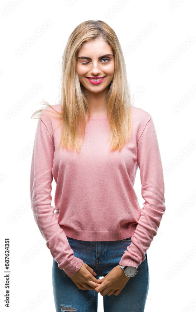 Young beautiful blonde woman wearing pink winter sweater over isolated background winking looking at the camera with sexy expression, cheerful and happy face. Young beautiful blonde woman wearing pink winter sweater over isolated background winking looking at the camera with sexy expression, cheerful and happy face.