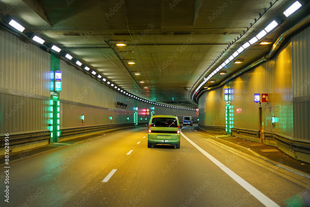 City road tunnel with cars on the road and artificial lighting. City road tunnel with cars on the road and artificial lighting.