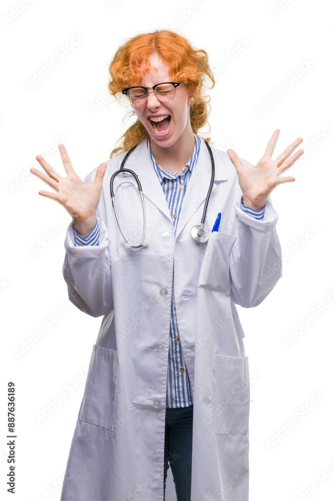 Young redhead woman wearing doctor uniform celebrating mad and crazy for success with arms raised and closed eyes screaming excited. Winner concept Young redhead woman wearing doctor uniform celebrating mad and crazy for success with arms raised and closed eyes screaming excited. Winner concept