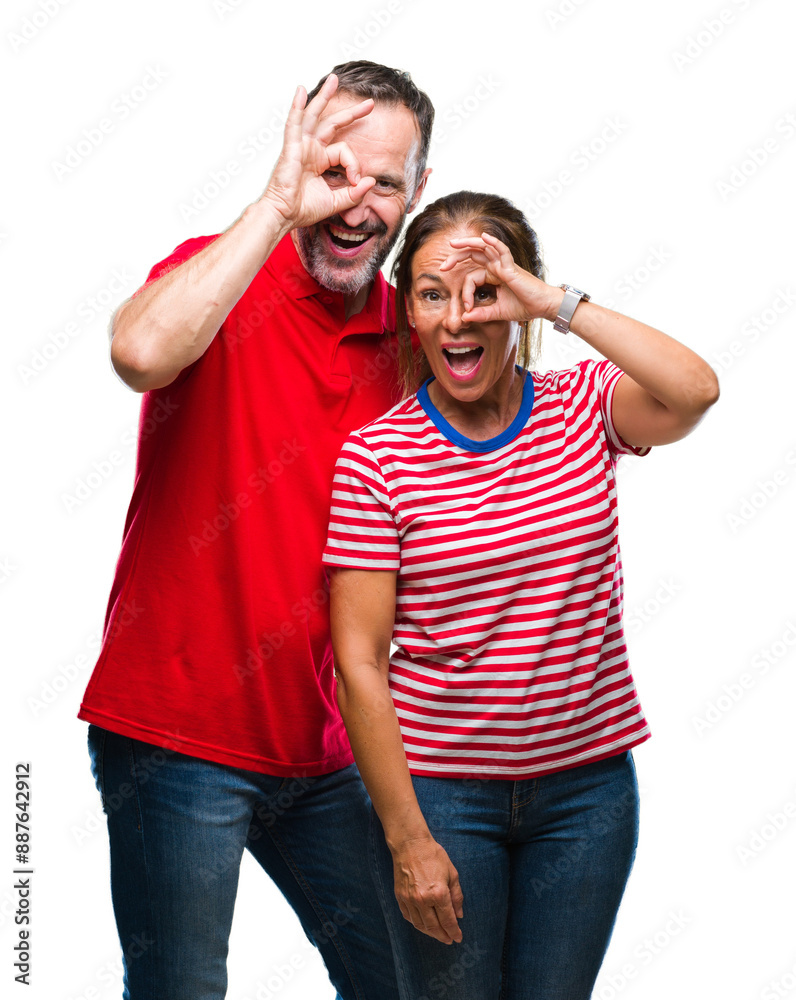 Middle age hispanic couple in love over isolated background doing ok gesture with hand smiling, eye looking through fingers with happy face. Middle age hispanic couple in love over isolated background doing ok gesture with hand smiling, eye looking through fingers with happy face.