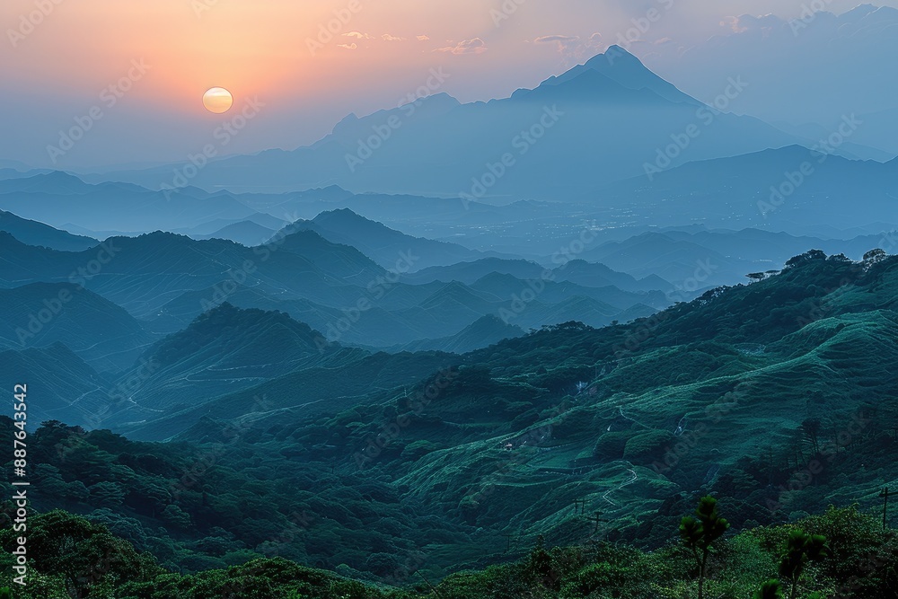 Sunset over the mountains casts a golden glow on the landscape below Sunset over the mountains casts a golden glow on the landscape below