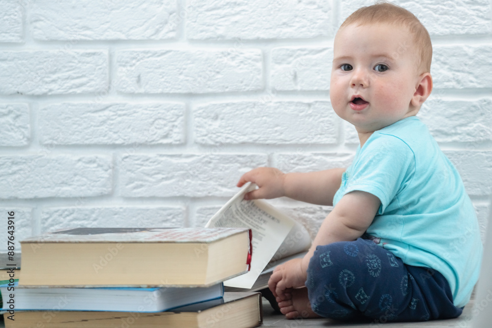 Little baby looks at a books. Intellectual development of newborns. Copy space for text or design. Little baby looks at a books. Intellectual development of newborns. Copy space for text or design.