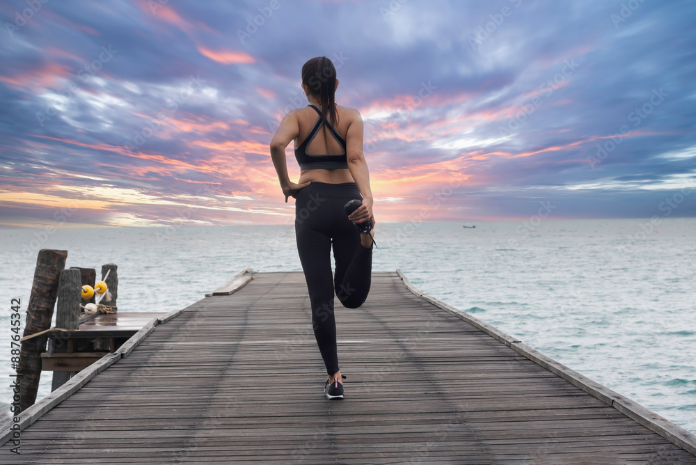 Fototapeta premium Young healthy woman practicing yoga on the bridge in the nature