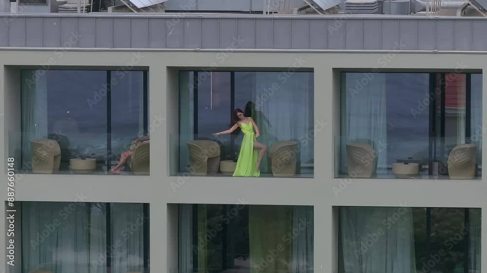 Beautiful girl in a long green dress standing on a balcony of the luxury hotel. Beautiful fashion model girl. Beautiful girl in a long green dress standing on a balcony of the luxury hotel. Beautiful fashion model girl.