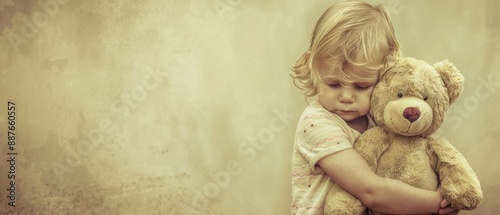 Wallpaper Mural A nostalgic image of a young child hugging a teddy bear, capturing a moment of sadness and comfort against a vintage background. Torontodigital.ca