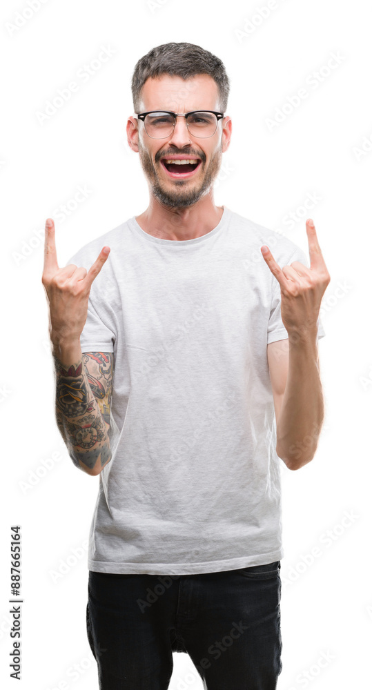 Young tattooed adult man shouting with crazy expression doing rock symbol with hands up. Music star. Heavy concept. Young tattooed adult man shouting with crazy expression doing rock symbol with hands up. Music star. Heavy concept.