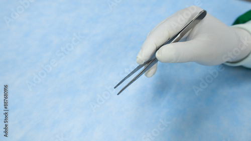 Cuadro en lienzo Hand in white glove holds stainless medical forcep