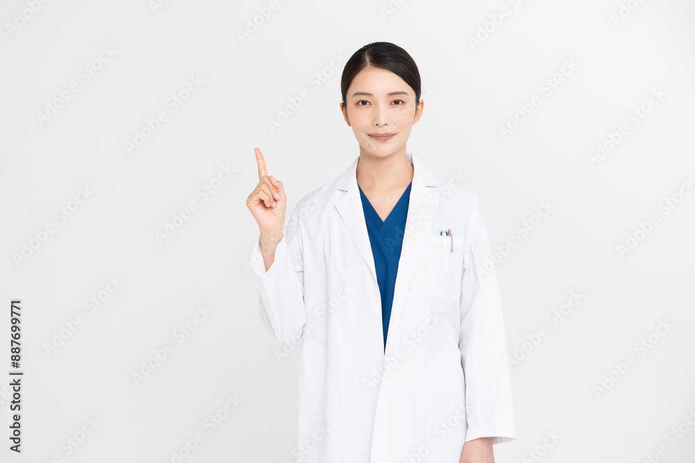 女性医師が指差しをしている。/スタジオ撮影白背景、ジェスチャー 女性医師が指差しをしている。/スタジオ撮影白背景、ジェスチャー