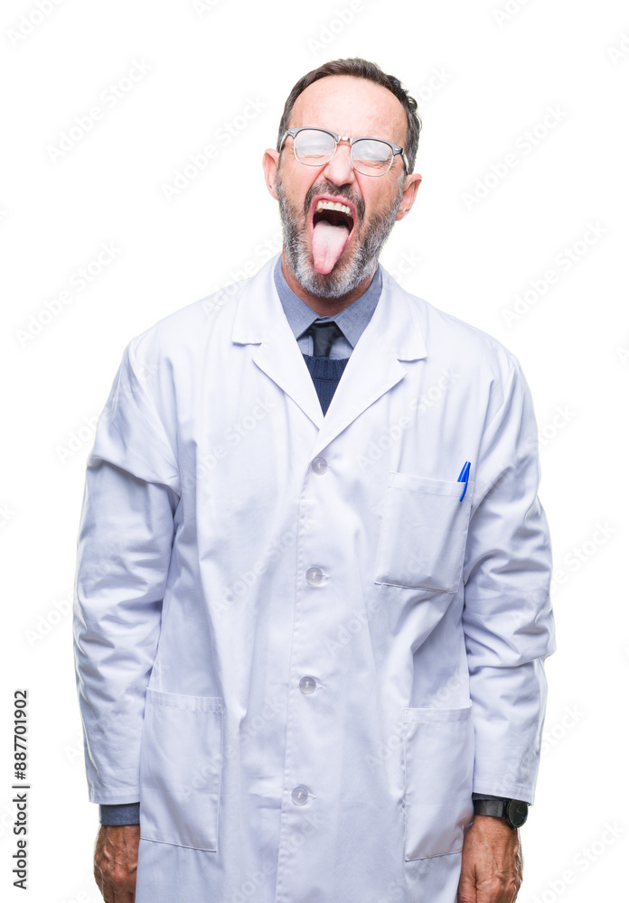 Middle age senior hoary professional man wearing white coat over isolated background sticking tongue out happy with funny expression. Emotion concept.
