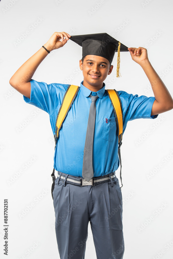 Indian Asian student, school boy in uniform with graduation cap, proudly displaying certificate roll Indian Asian student, school boy in uniform with graduation cap, proudly displaying certificate roll