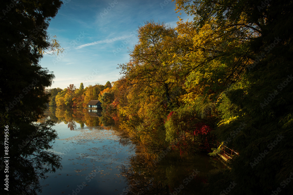 Landscape with beautiful house on a lake with colourful leafs in autumn season