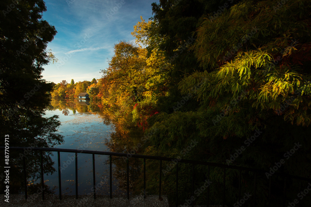 Landscape with beautiful house on a lake with colourful leafs in autumn season