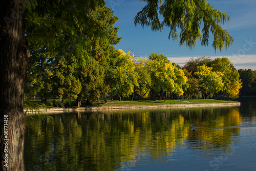 Obraz na płótnie Park at sunrise with beautiful autumn colors and lake in background w salonie