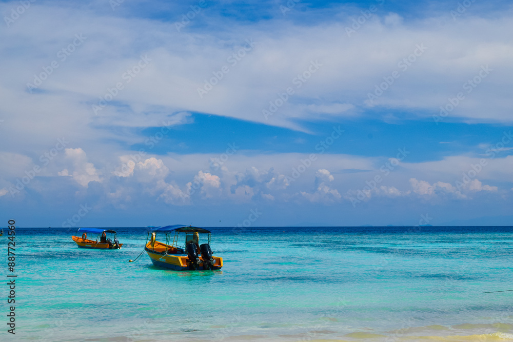 Aerial view of Perhentian Islands beach with boats docked near a wooden pier and lush greenery Aerial view of Perhentian Islands beach with boats docked near a wooden pier and lush greenery
