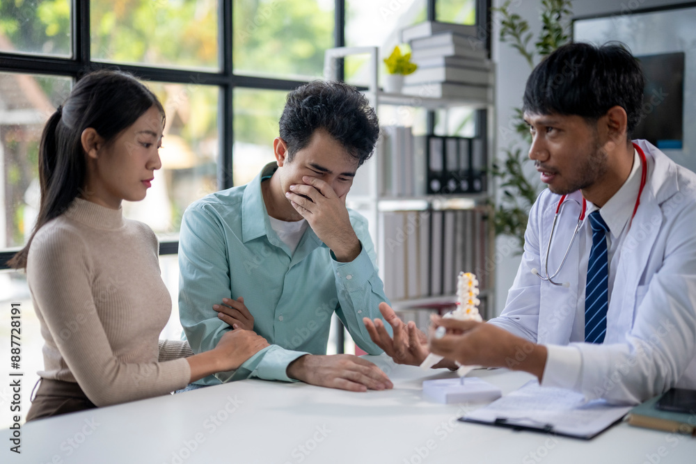 A man and a woman are sitting at a table with a doctor A man and a woman are sitting at a table with a doctor
