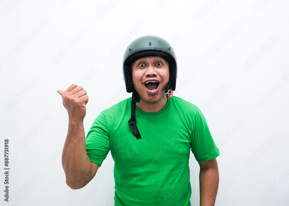 A man wearing motorcycle helmet smiling and pointing beside him A man wearing motorcycle helmet smiling and pointing beside him