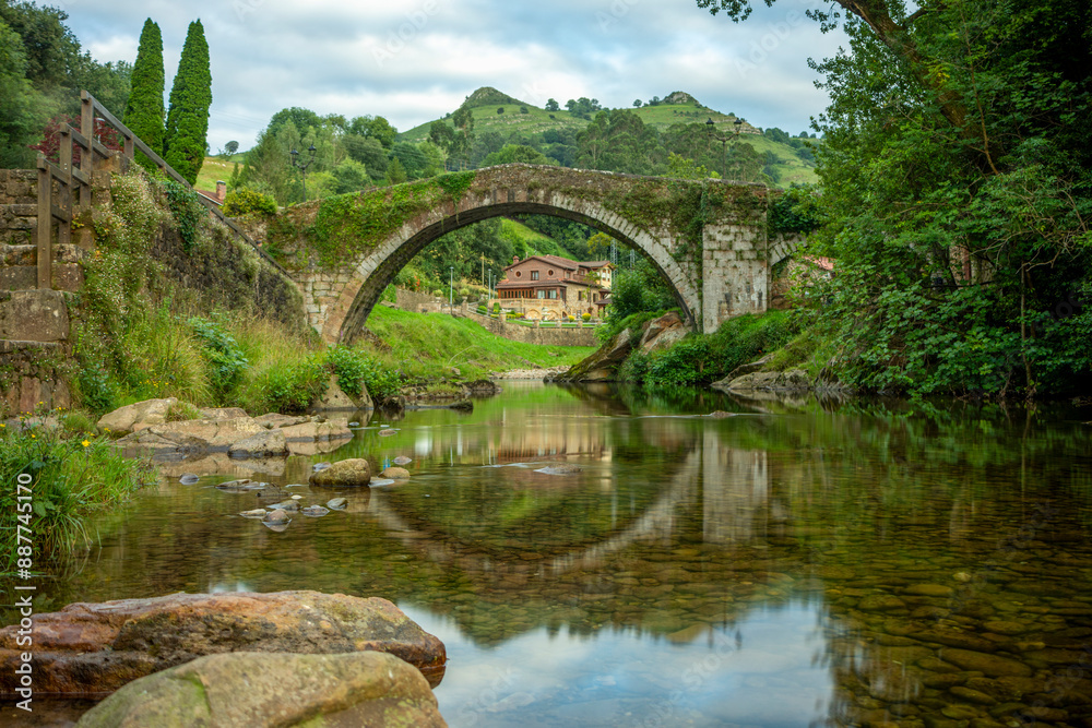 Medieval semicircular arch bridge over the Miera river, Liérganes, Cantabria, Spain, with its reflection in its waters Medieval semicircular arch bridge over the Miera river, Liérganes, Cantabria, Spain, with its reflection in its waters