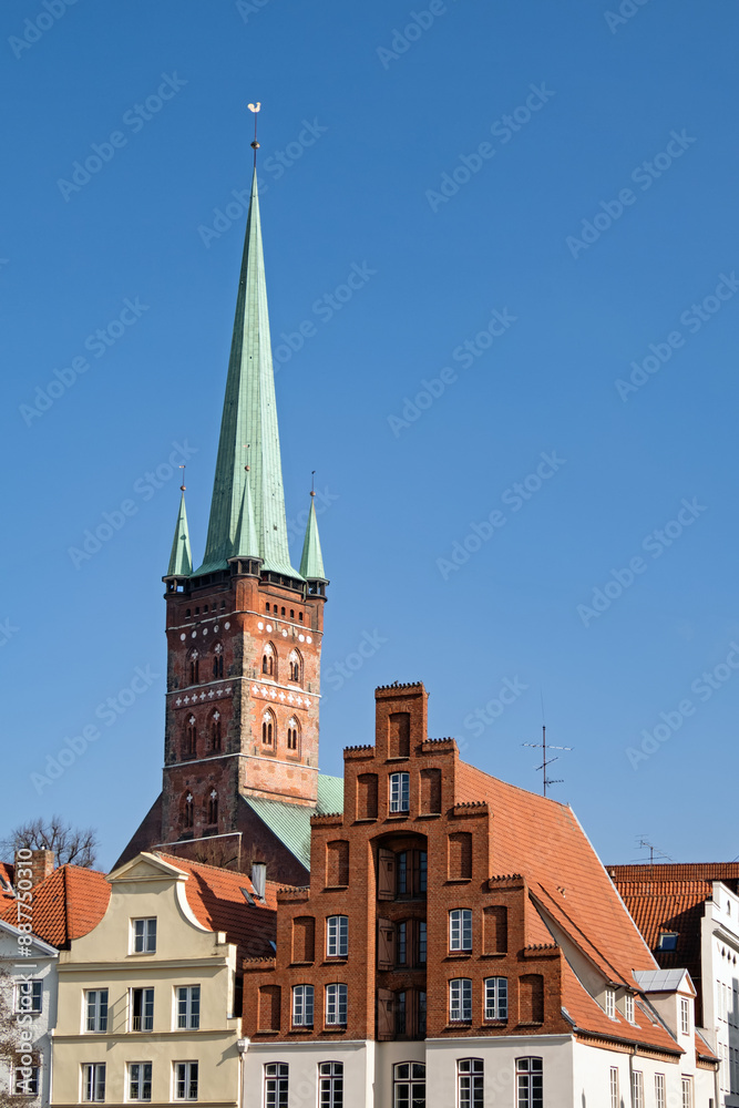 Turm der Kirche St. Petri in Lübeck, Deutschland, der neben den Giebeln alter Häuser emporragt Turm der Kirche St. Petri in Lübeck, Deutschland, der neben den Giebeln alter Häuser emporragt