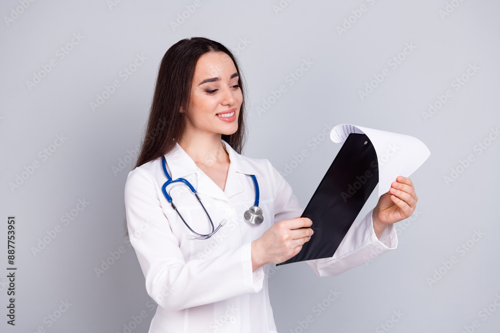 Photo of professional medical worker lady read clipboard white coat isolated on grey color background Photo of professional medical worker lady read clipboard white coat isolated on grey color background
