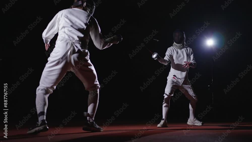 Pair Of Professional Fencers In Fencing Masks Fighting In Black Background, Slow Motion Shot Pair Of Professional Fencers In Fencing Masks Fighting In Black Background, Slow Motion Shot