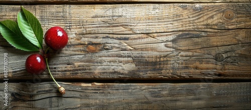 Old wooden table with a sour cherry and leaf providing an attractive backdrop for copy space image