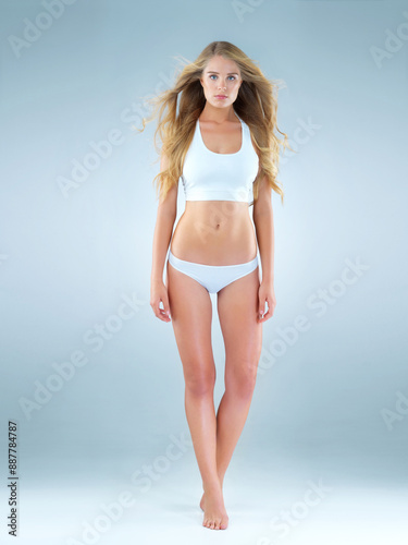 Underwear, woman and portrait in studio for confidence, healthy body and wind on mock up space. Beauty, female model and fearless on blue background with fitness results, wellness and diet benefits