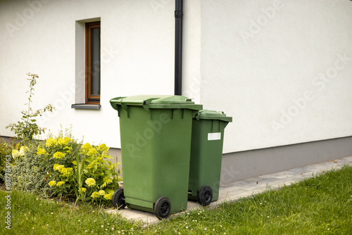 Obraz na płótnie Two Big empty green plastic trash garbage bin in front of the modern house. Plastic pollution problem. Green recycling containers w salonie