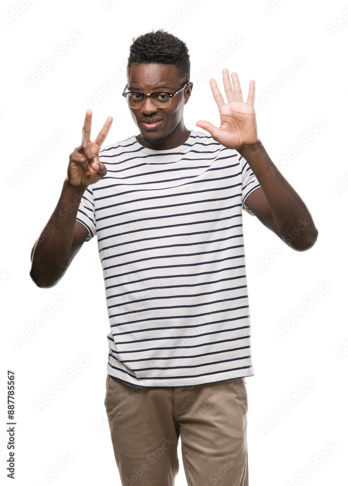 Fototapeta premium Young african american man wearing glasses and navy t-shirt showing and pointing up with fingers number seven while smiling confident and happy.