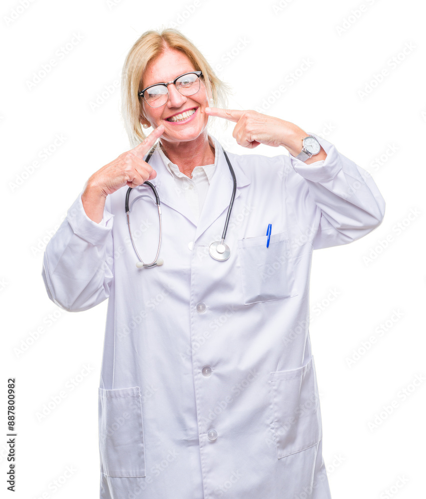 Middle age blonde doctor woman over isolated background smiling confident showing and pointing with fingers teeth and mouth. Health concept. Middle age blonde doctor woman over isolated background smiling confident showing and pointing with fingers teeth and mouth. Health concept.