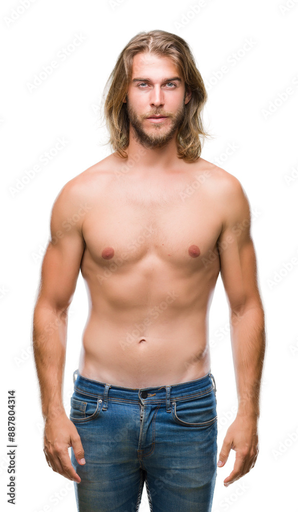 Young handsome shirtless man with long hair showing sexy body over isolated background with serious expression on face. Simple and natural looking at the camera. Young handsome shirtless man with long hair showing sexy body over isolated background with serious expression on face. Simple and natural looking at the camera.