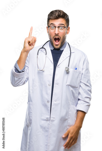 Young handsome doctor man over isolated background pointing finger up with successful idea. Exited and happy. Number one.