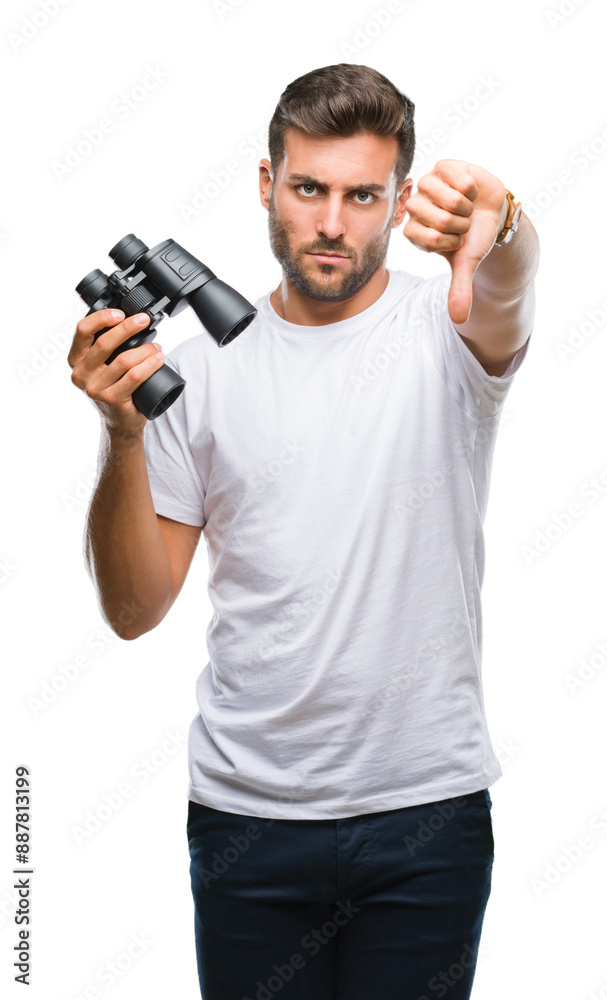 Young handsome man looking through binoculars over isolated background with angry face, negative sign showing dislike with thumbs down, rejection concept Young handsome man looking through binoculars over isolated background with angry face, negative sign showing dislike with thumbs down, rejection concept