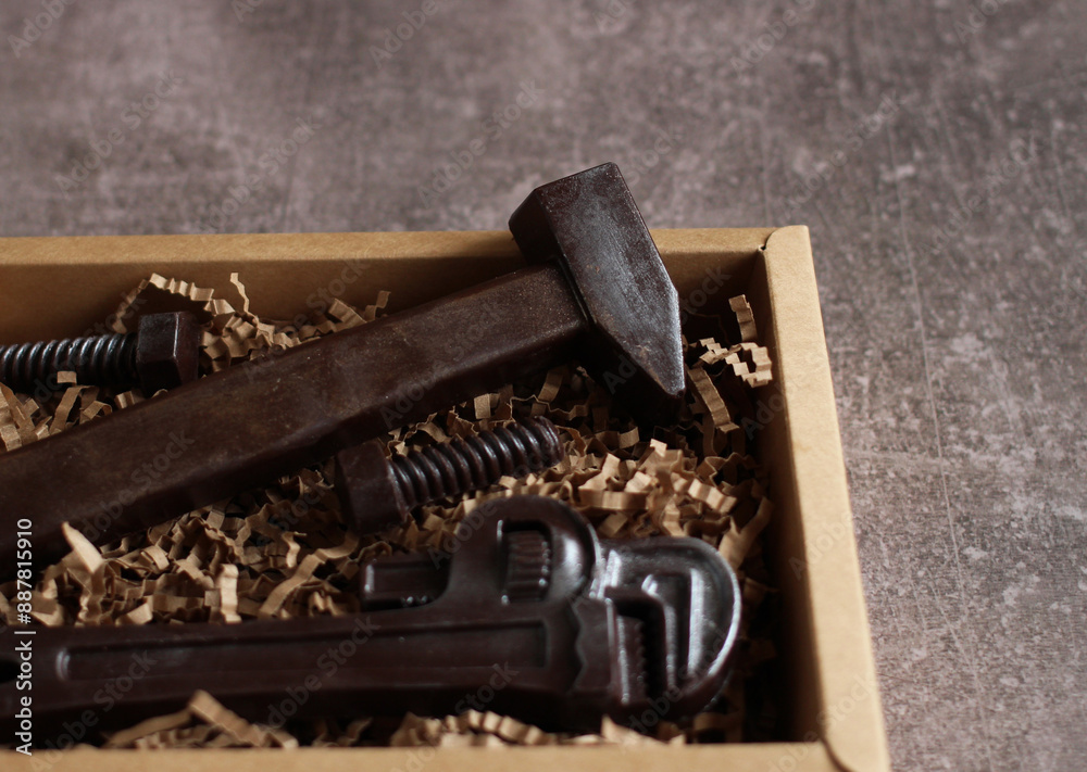 Close-up of chocolate tools in cardboard box on gray background Close-up of chocolate tools in cardboard box on gray background