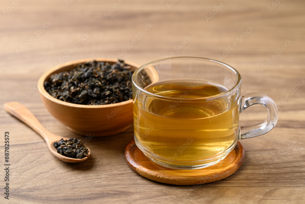 Oolong tea in cup glass with dried Oolong tea leaves on wooden background, Healthy drink Oolong tea in cup glass with dried Oolong tea leaves on wooden background, Healthy drink