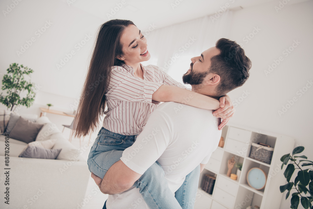 Fototapeta premium Photo of cheerful cute young couple enjoy weekend couple husband hold wife embrace buy new apartment indoors inside house home