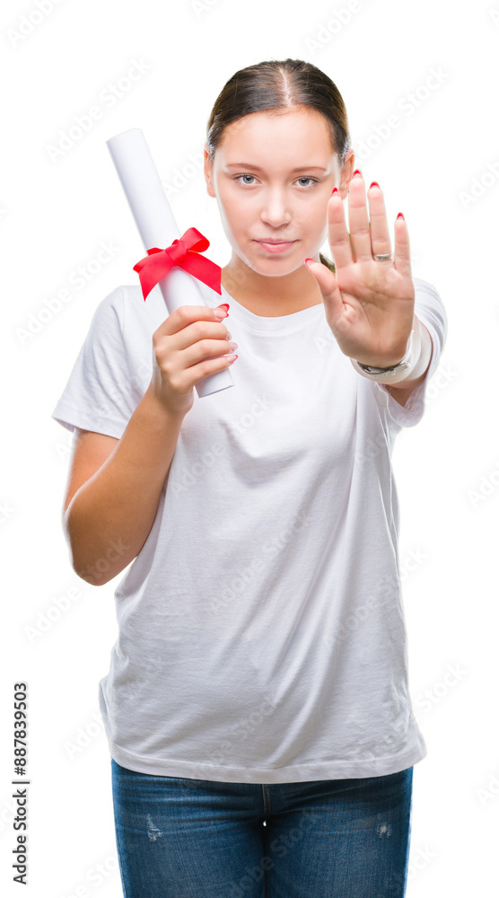 Young caucasian woman holding degree over isolated background with open hand doing stop sign with serious and confident expression, defense gesture Young caucasian woman holding degree over isolated background with open hand doing stop sign with serious and confident expression, defense gesture
