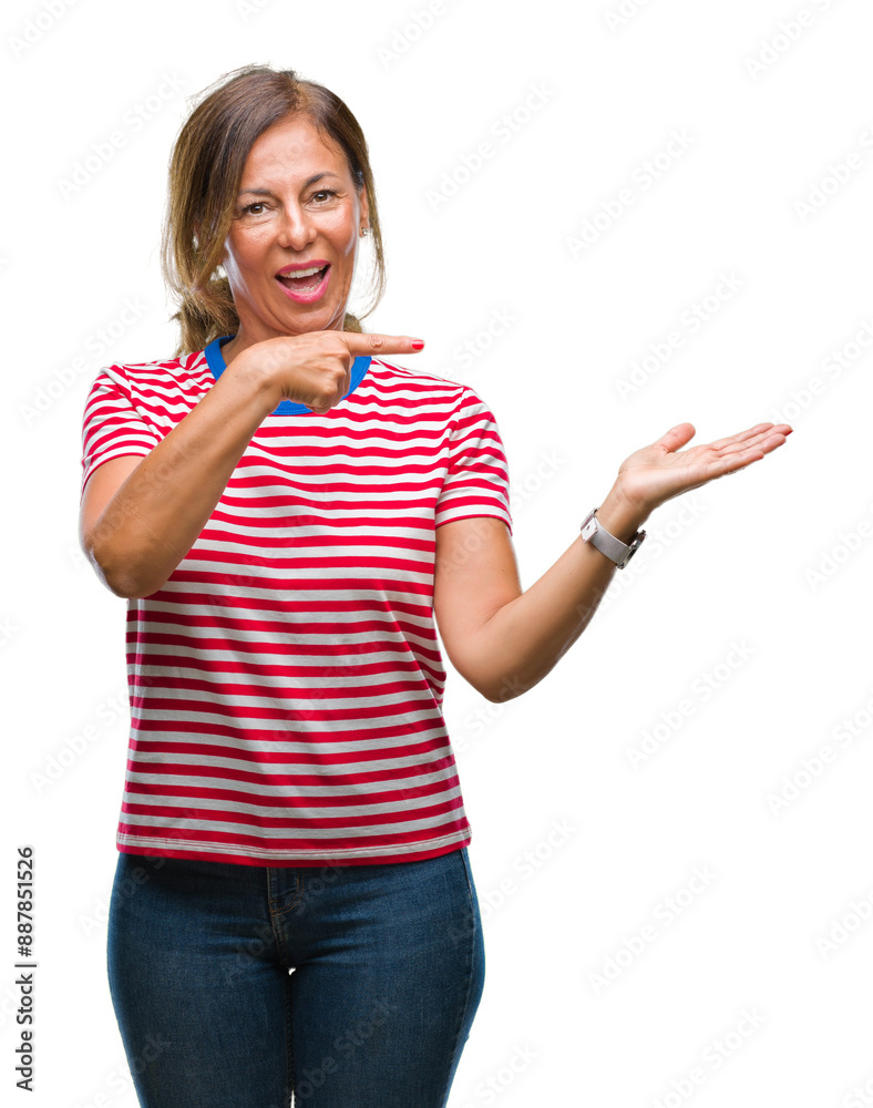 Middle age senior hispanic woman over isolated background amazed and smiling to the camera while presenting with hand and pointing with finger.
