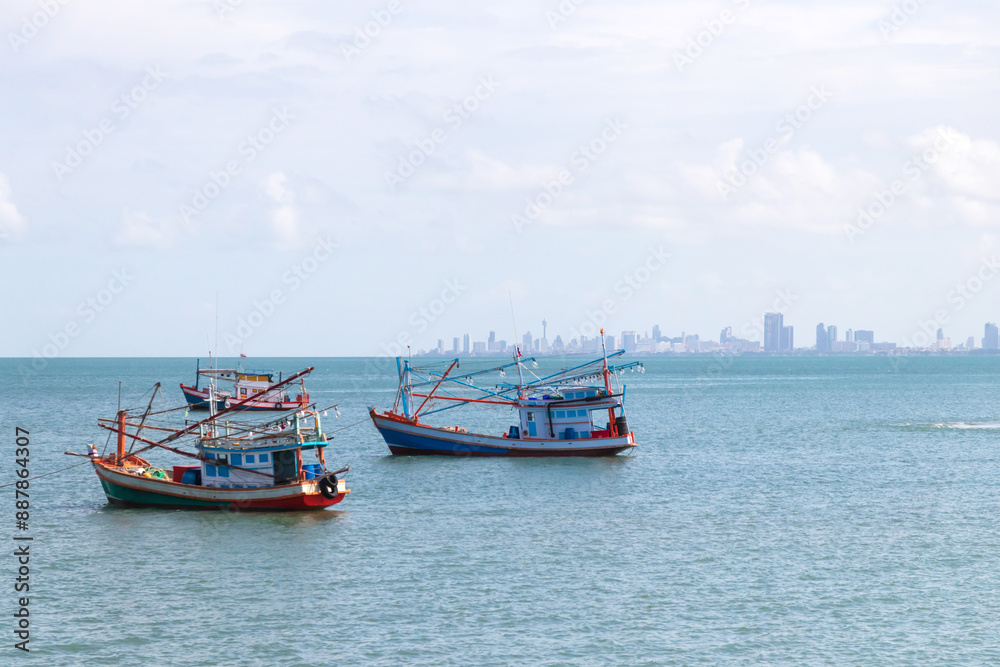 Fishing boat floating on the sea with city on background. Fishing boat floating on the sea with city on background.