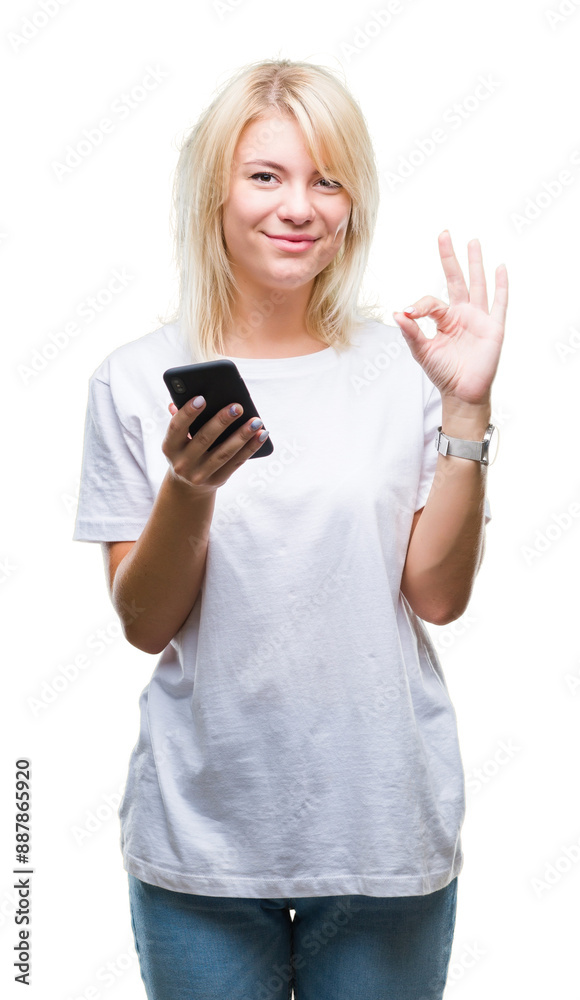 Young beautiful blonde woman using smartphone over isolated background doing ok sign with fingers, excellent symbol