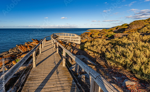 Wooden walkway and viewing platform along the natural orange rock formations on the coastline in Penneshaw, Kangaroo Island, South Australia